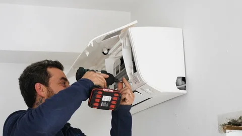  using the drill  mounting the air conditioner to the wall Video stock 86250933