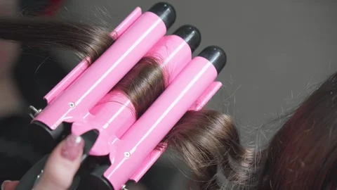 Using electric curling iron to create wavy hair. Stock Footage 260949365
