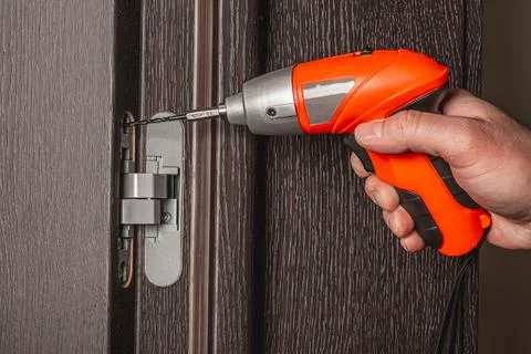 Using an electric screwdriver to install the door Foto stock