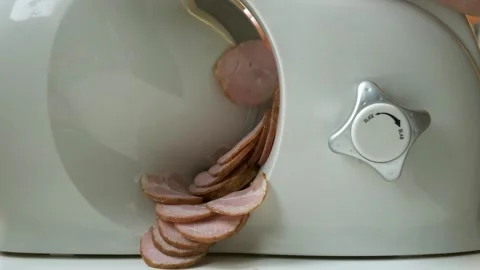Using electric slicer to slice salami or meat Stock Footage 253504732
