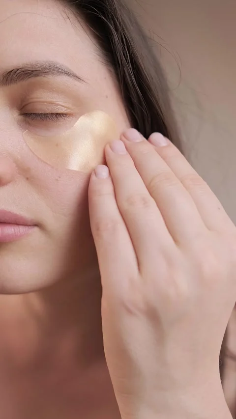 Using eye patches for facial hydration, a part of at-home skincare routine for Stock Footage 304890288