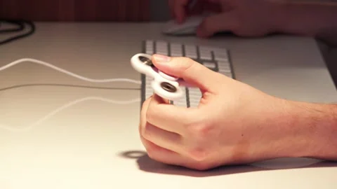 Using a fidget spinner when working on computer 1 Stock Footage 130865529