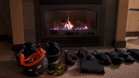 Using a fireplace to dry gloves in winter ski season Stock Footage 145553126
