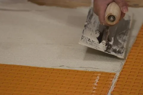 Using a flat square trowel to smooth and spread cement Foto stock
