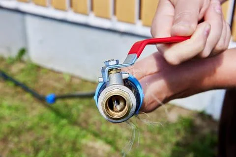 Using flexible HDPE pipe for watering garden, metal ball valve with lever is Foto stock