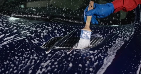 Using a foaming brush washer at a manual car wash. Car detailing. Stock Footage 94899165