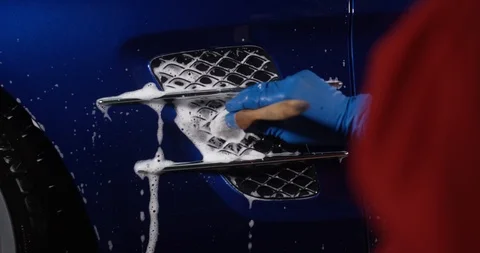 Using a foaming brush washer at a manual car wash. Car detailing. Video stock 94899314