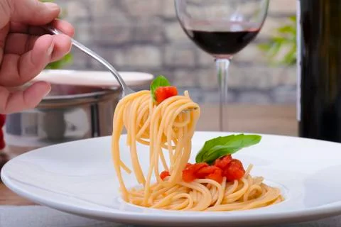 Using a fork to pick up spaghetti from a dish Stock Photos
