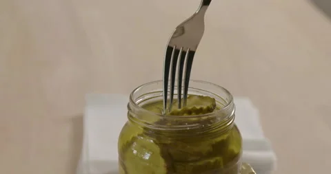 Using fork to take pickled cucumber form glass jar Stock Footage 131926134
