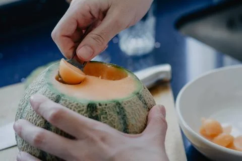 Using a fruit punch on a cantaloupe Fotos de archivo