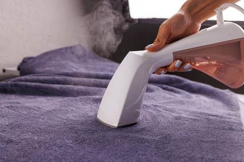 Using a Garment Steamer on Purple Fabric Stock Photos