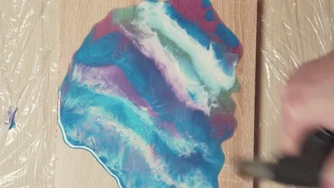 Using a gas burner to move pigmented epoxy resin. Making art panels, handmade. Video stock 153547934