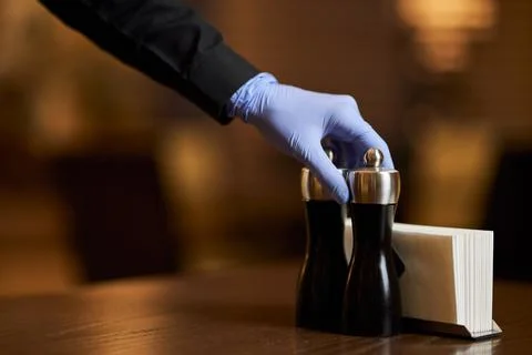 Using gloves while serving tables is a must during pandemic Stock Photos