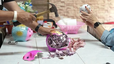 Using a hammer to break a savings bank Stock Footage 263692291