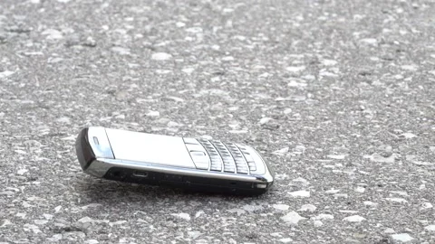 Using a hammer to smash a smart phone sitting on the ground Vídeo Stock 154549640