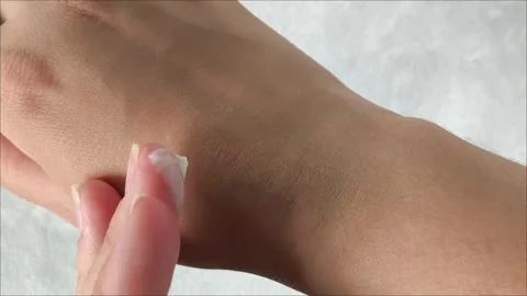 Using hand cream for dry skin close-up moisturizing palms and treating Stock Footage 313653216