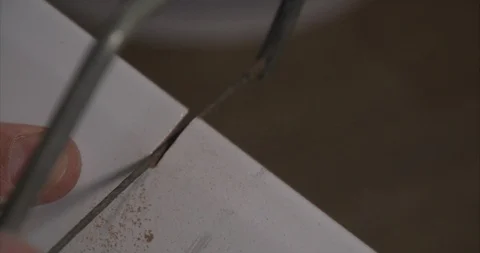 Using a hand masonry saw to cut a white wall tile Stock Footage 101624554