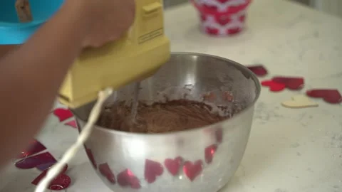 Using a hand mixer to mix chocolate cake making a special valentine's day Stock Footage 270514506
