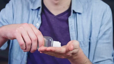 Using hand sanitizer and rubbing into hands - slow motion Stock Footage 128837980