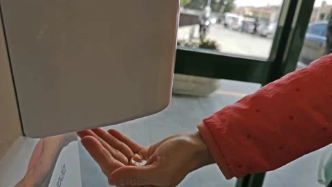 Using hand sanitizer in public place Stock Footage 130329748