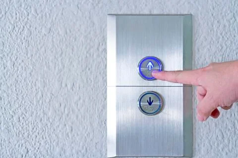 Using hands, press the elevator up and keypad elevator Stock Photos