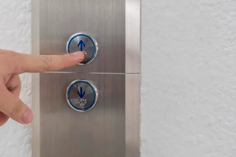 Using hands, press the elevator up and keypad elevator Stock Photos