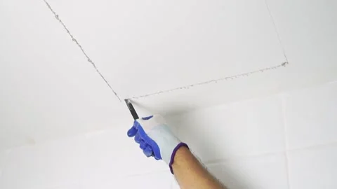 Using a handsaw cutting to cut a hole in the ceiling to install the service port Stock Footage 232215124