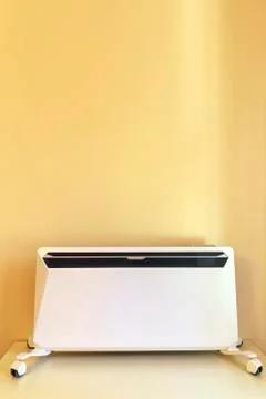 Using heater at home in winter. Heating season. Modern Electric Heater with c Stock Photos