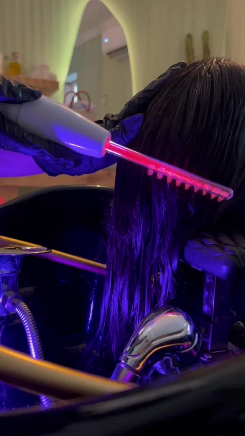 Using high frequency comb on hair in salon, vertical close-up shot Stock Footage 345165922
