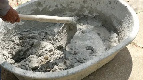 Using a hoe for concrete mixer, Bucket for mixing cement for construction Stock Footage 132788310