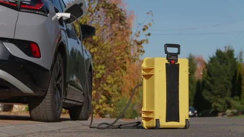 Using of home-invented portable battery to charge electric car out of the city Stock Footage 221867381
