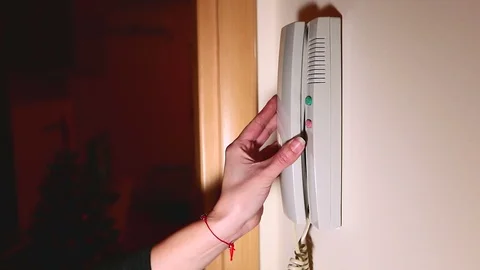 Using house intercom system. Woman using the intercom in the apartment Stock Footage 102801476