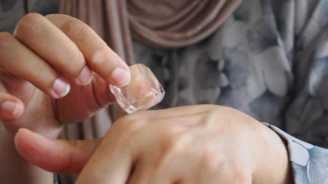 Using ice cubes on your skin can provide a soothing and refreshing effect Stock Footage 345386992