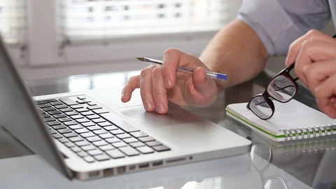 Using internet, hands of businessman with glasses on laptop touchpad Stock Footage 98100520