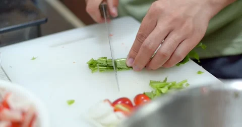 Using a knife cutting fresh parsley.Close up chopping of vegetable ingredients. Stock Footage 241679000