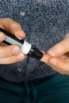 Using lancet device to prick finger for blood sugar test close up Stock Photos