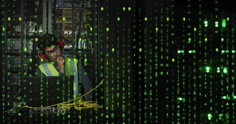 Using laptop with cables in server room under green overlay wearing vest and Foto stock