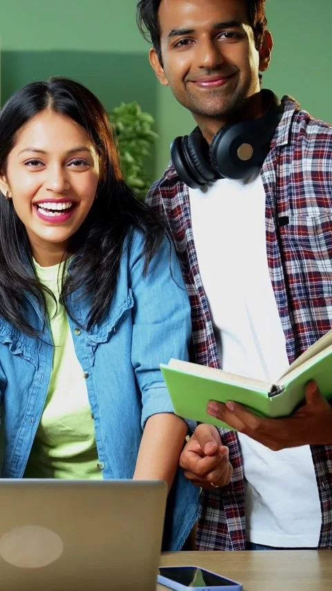 Using laptop, college students stand and study together with notes in library Video stock 342385026