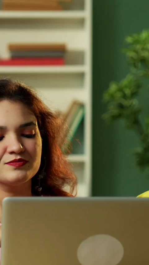 Using laptop to complete assignment Indian students studying together in library Stock Footage 342384998