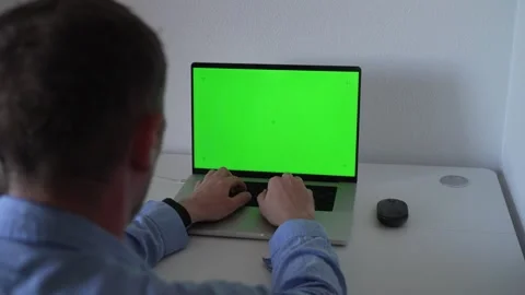 Using a laptop with a green screen for testing or filming in a home office Stock Footage 340189974