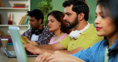 Using laptop, Indian students focus on group study with books notes in library Stock Footage 342383401