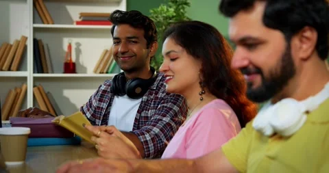 Using laptop, Indian students focus on group study with books notes in library Vídeo Stock 342383456