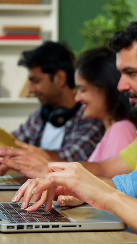 Using laptop, Indian students focus on group study with books notes in library Stock Footage 342385040