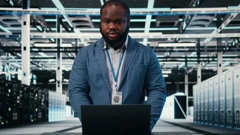 Using laptop, infrastructure and technician at server room workplace desk Stock Footage 330377185