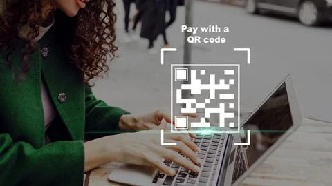 Using a laptop to pay online with a QR code in a busy outdoor area Fotos de archivo