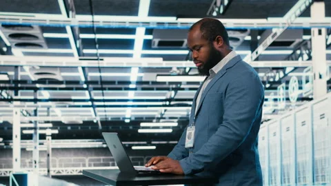 Using laptop, workspace desk and technician in server hub Stock Footage 330205627