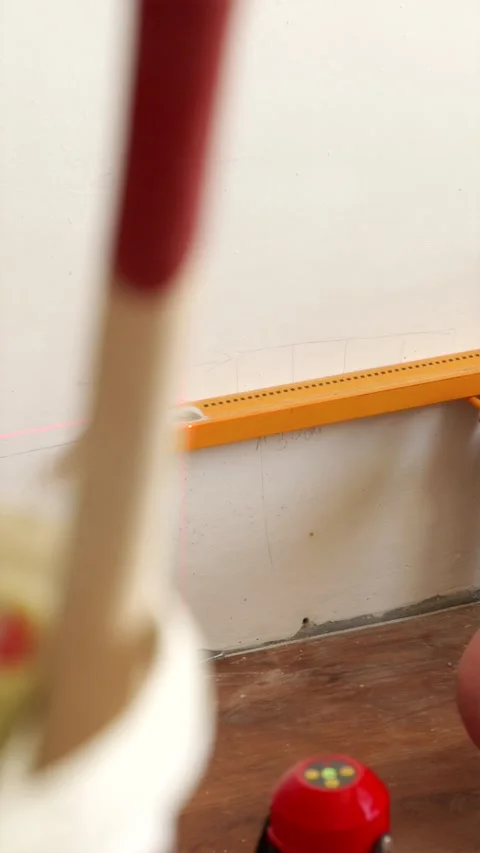 Using laser level and spirit level for wall channeling vertical Stock Footage 339298232