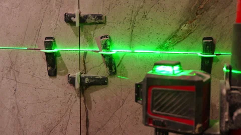 Using a laser level meter that projects green lines onto the walls Stock Footage 302195026