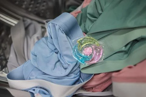 Using Laundry Detergent Pods While Doing Laundry in the Washing Machine with Stock Photos