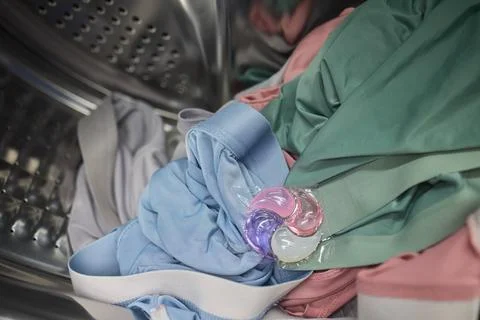 Using Laundry Detergent Pods While Doing Laundry in the Washing Machine with Stock Photos
